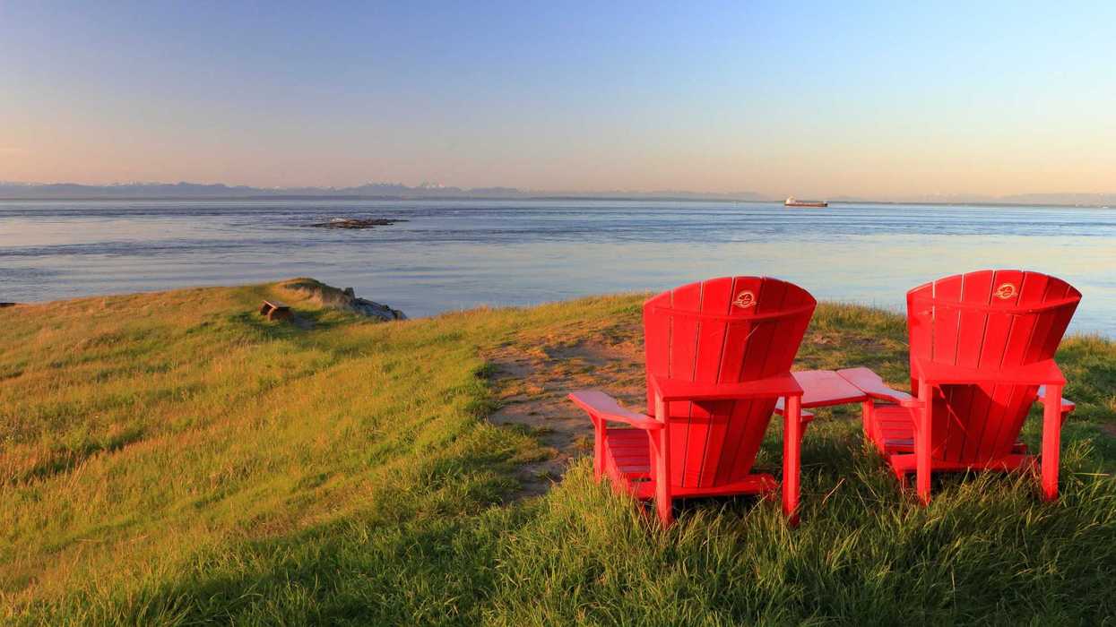 red parks canada chairs on grass overlooking water at national park in bc