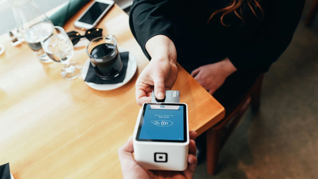 Restaurant customer pays on a credit card terminal.