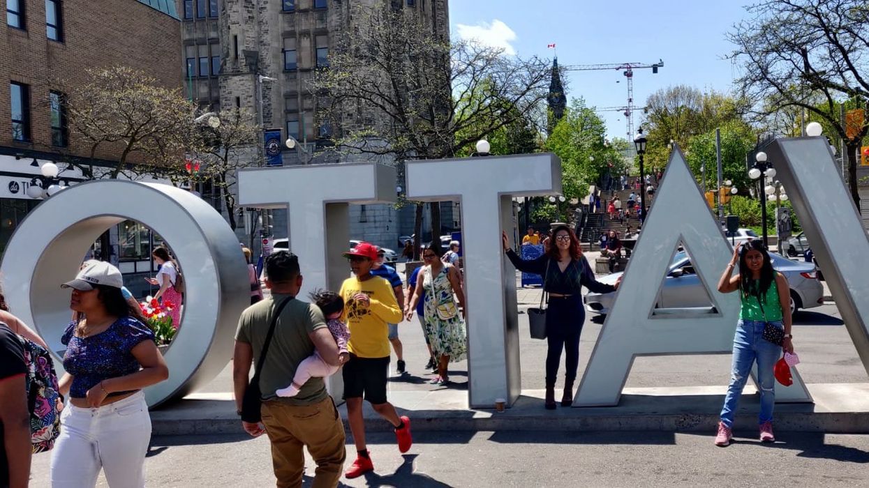 Rhythm Sachdeva posing with an Ottawa sign.