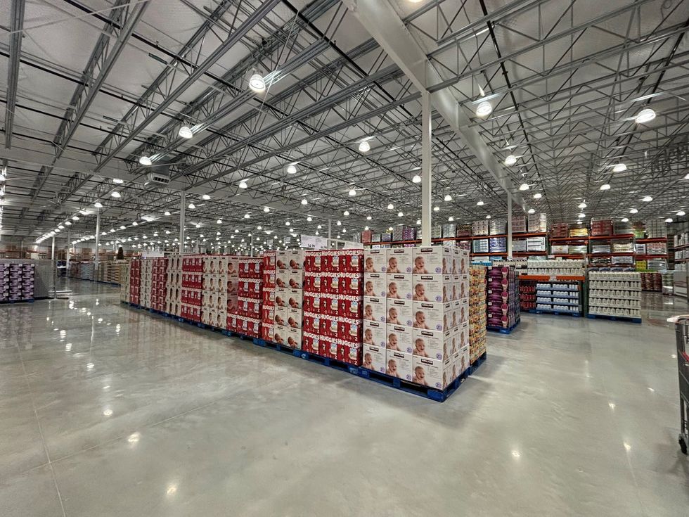Rows of stacked diapers and bulk items fill another spacious aisle in the Brantford Costco, showcasing the large warehouse-style organization.