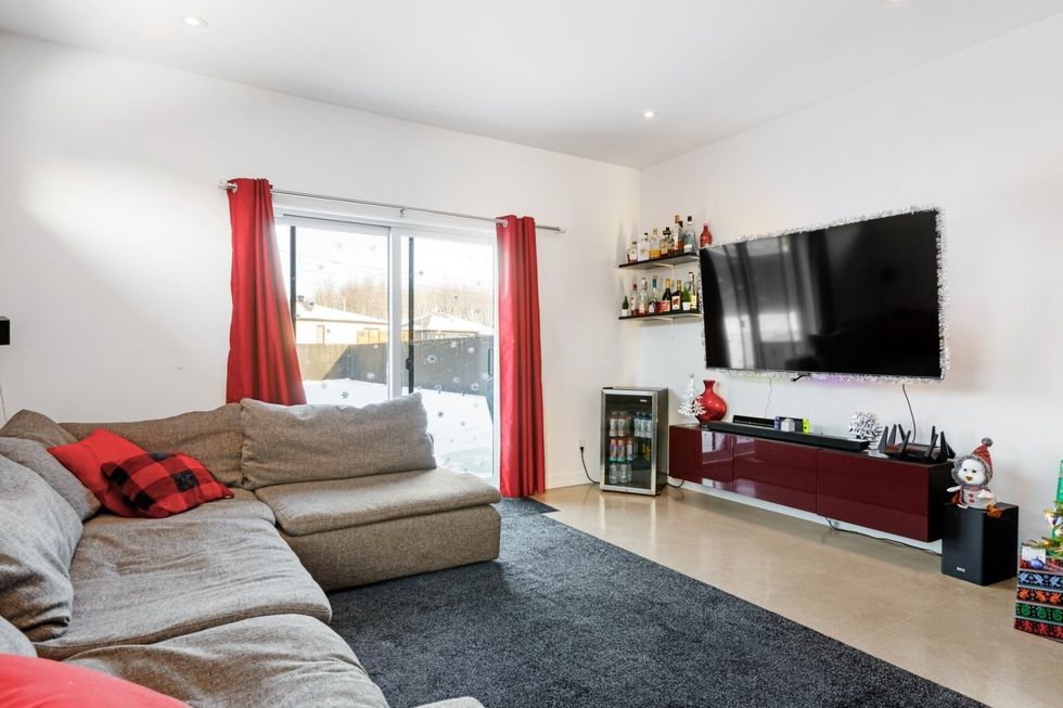 Salon avec divan sectionnel gris et accents rouges.