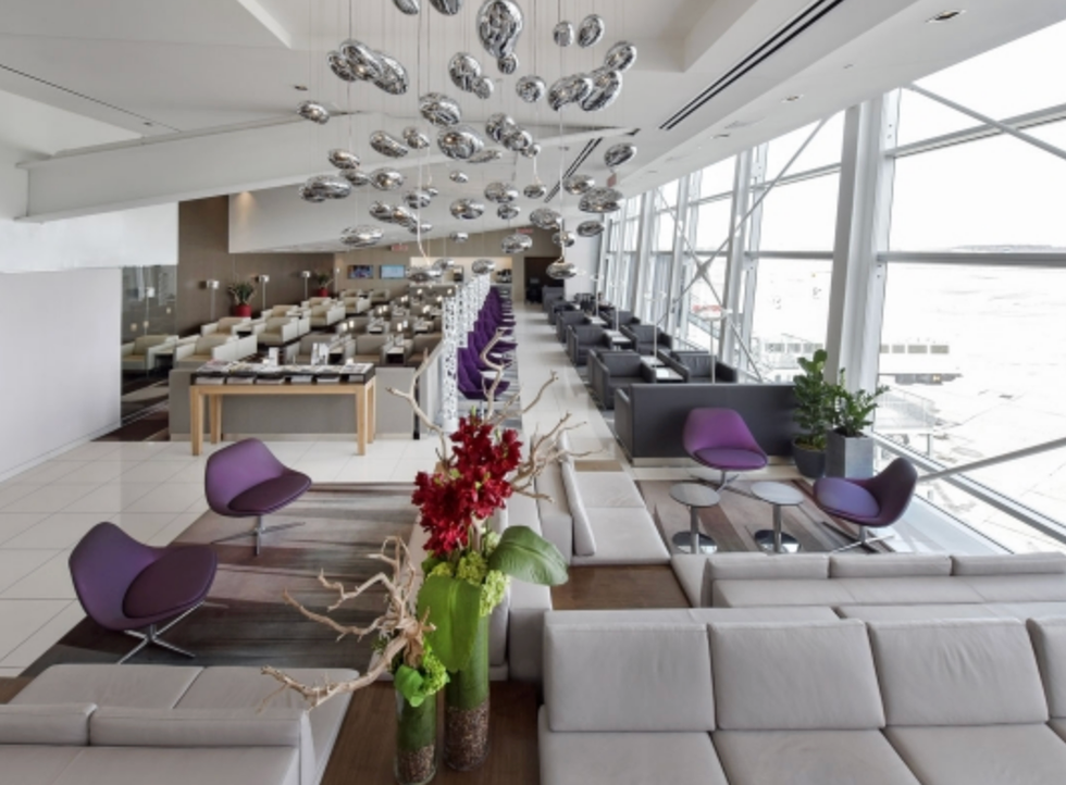 Salon priv\u00e9 avec canap\u00e9s gris et fauteuils mauves.