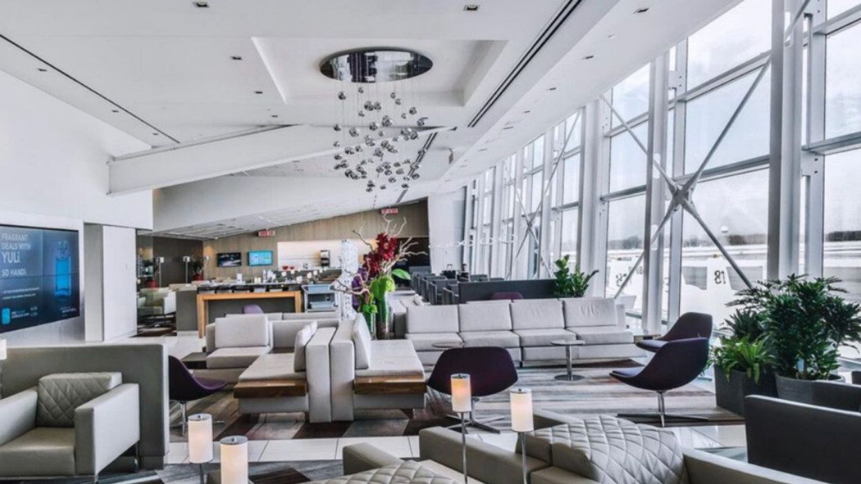 Salon privé avec canapés gris et fauteuils mauves.