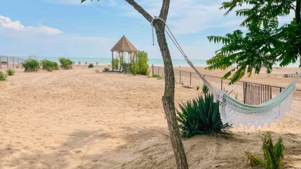 Sandy beach with a hammock and gazebo.