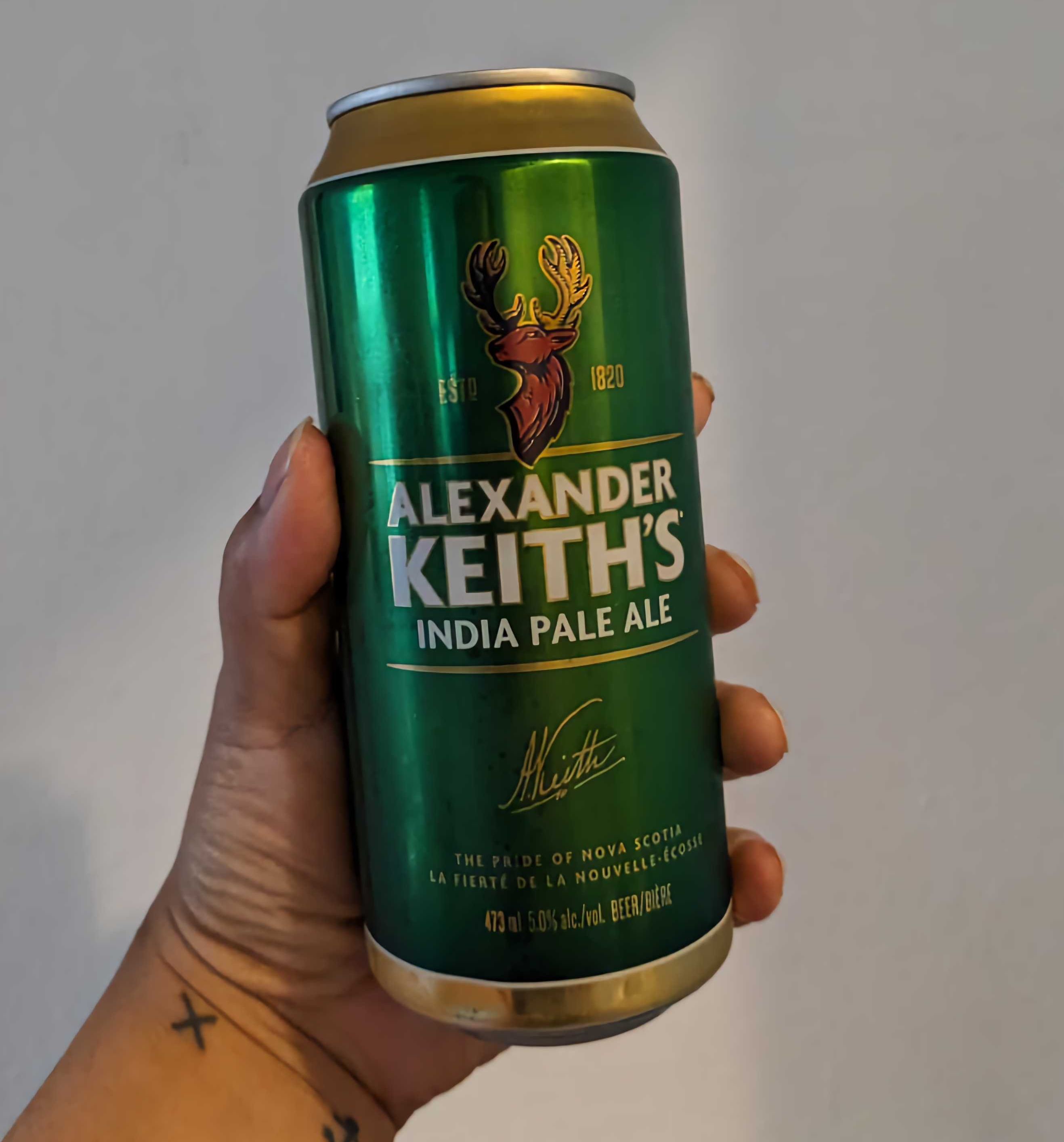 Sarah holding a can of Alexander Keith's India Pale Ale from the LCBO.
