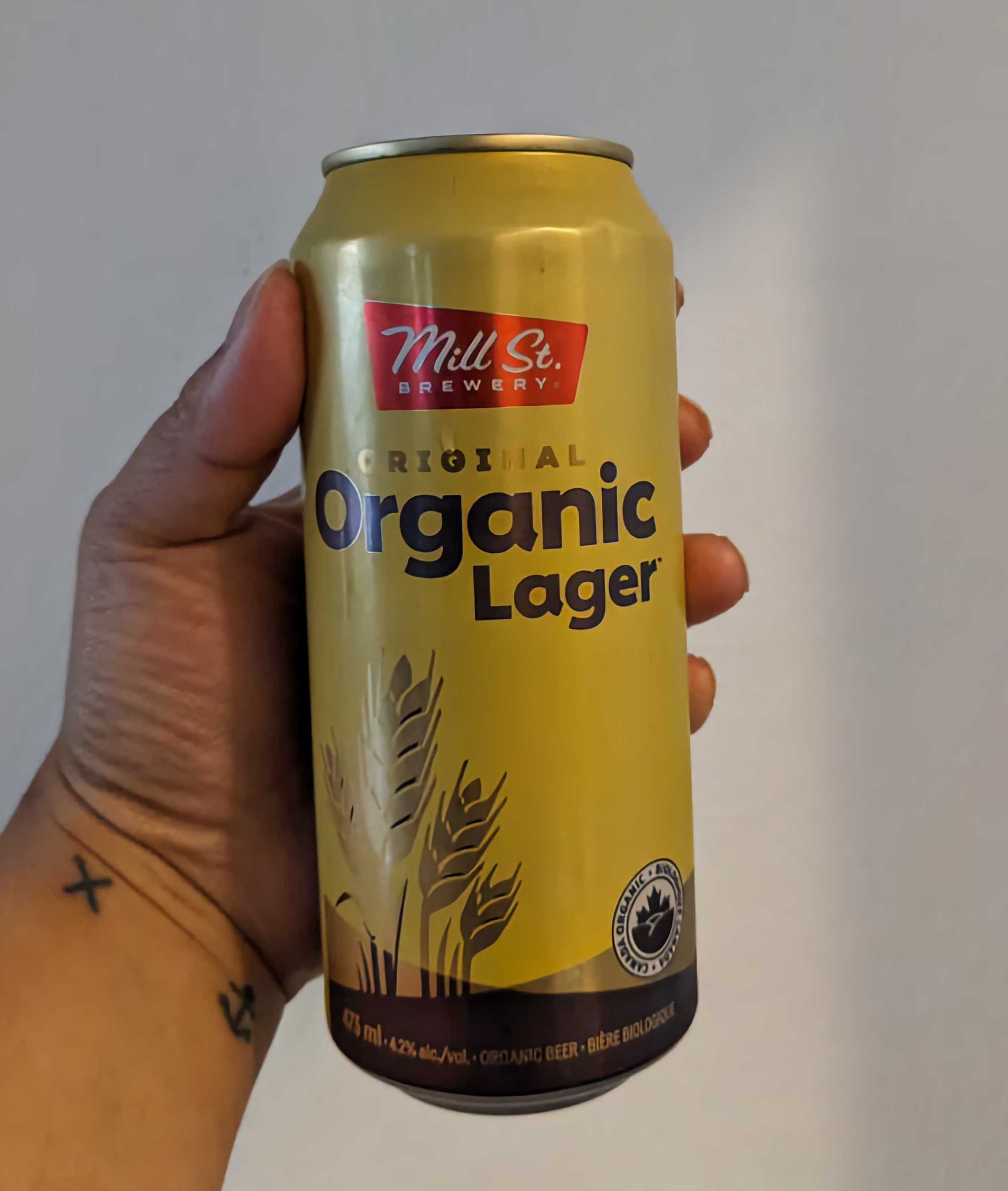 Sarah holding a can of Mill Street Original Organic Lager from the LCBO.