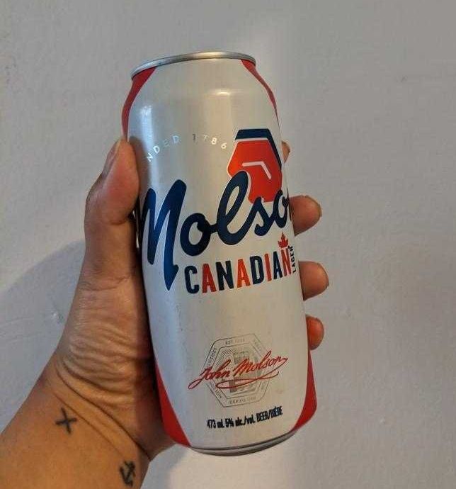 Sarah holding a can of Molson Canadian from the LCBO.
