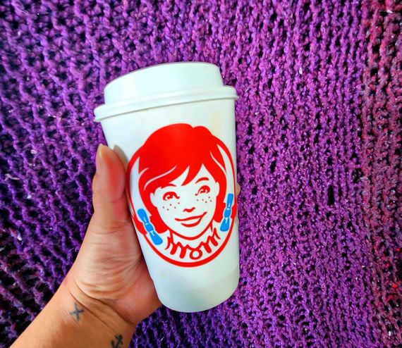 Sarah holding a large Wendy's coffee.