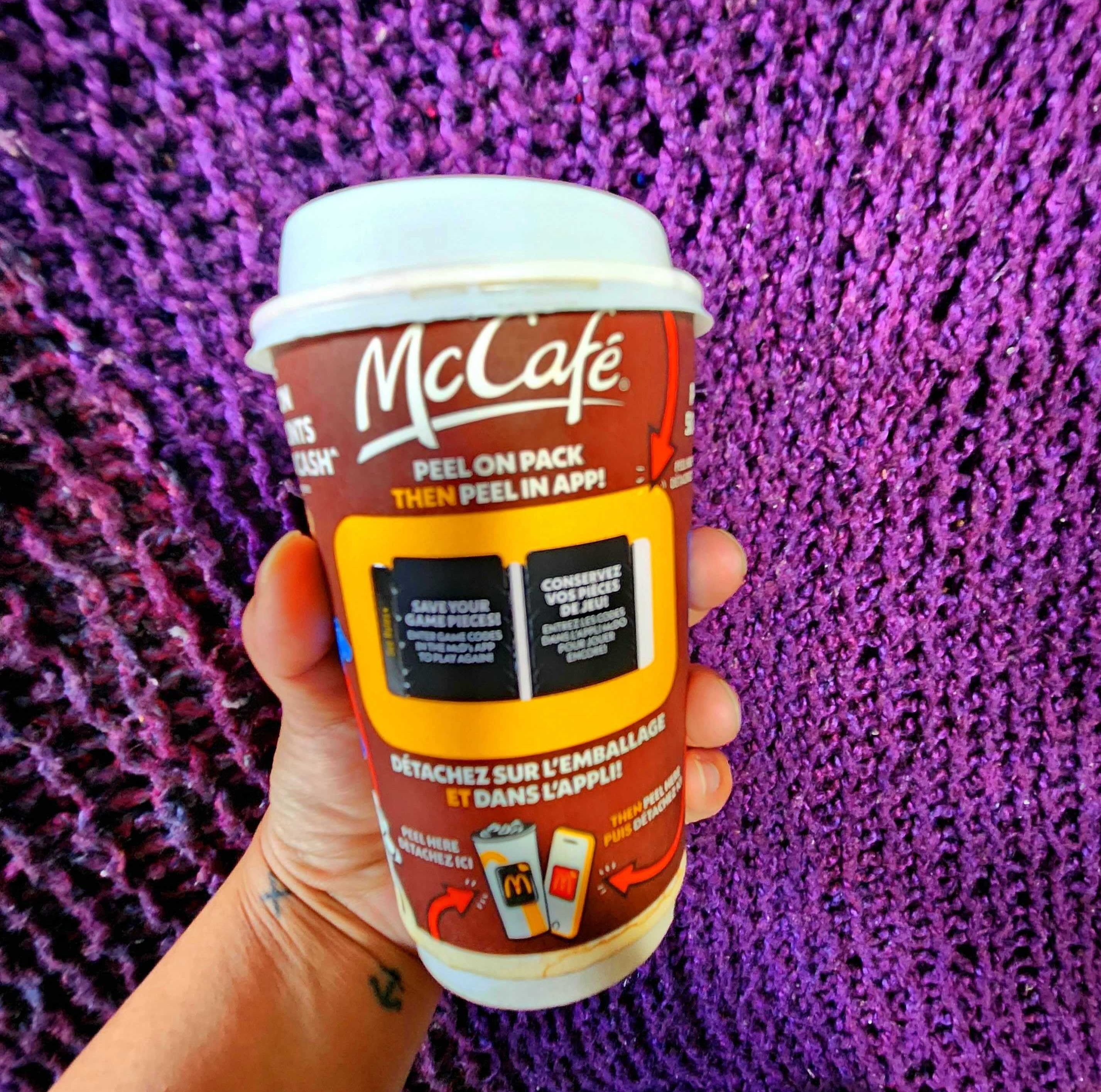 Sarah holding a medium McDonald's coffee.