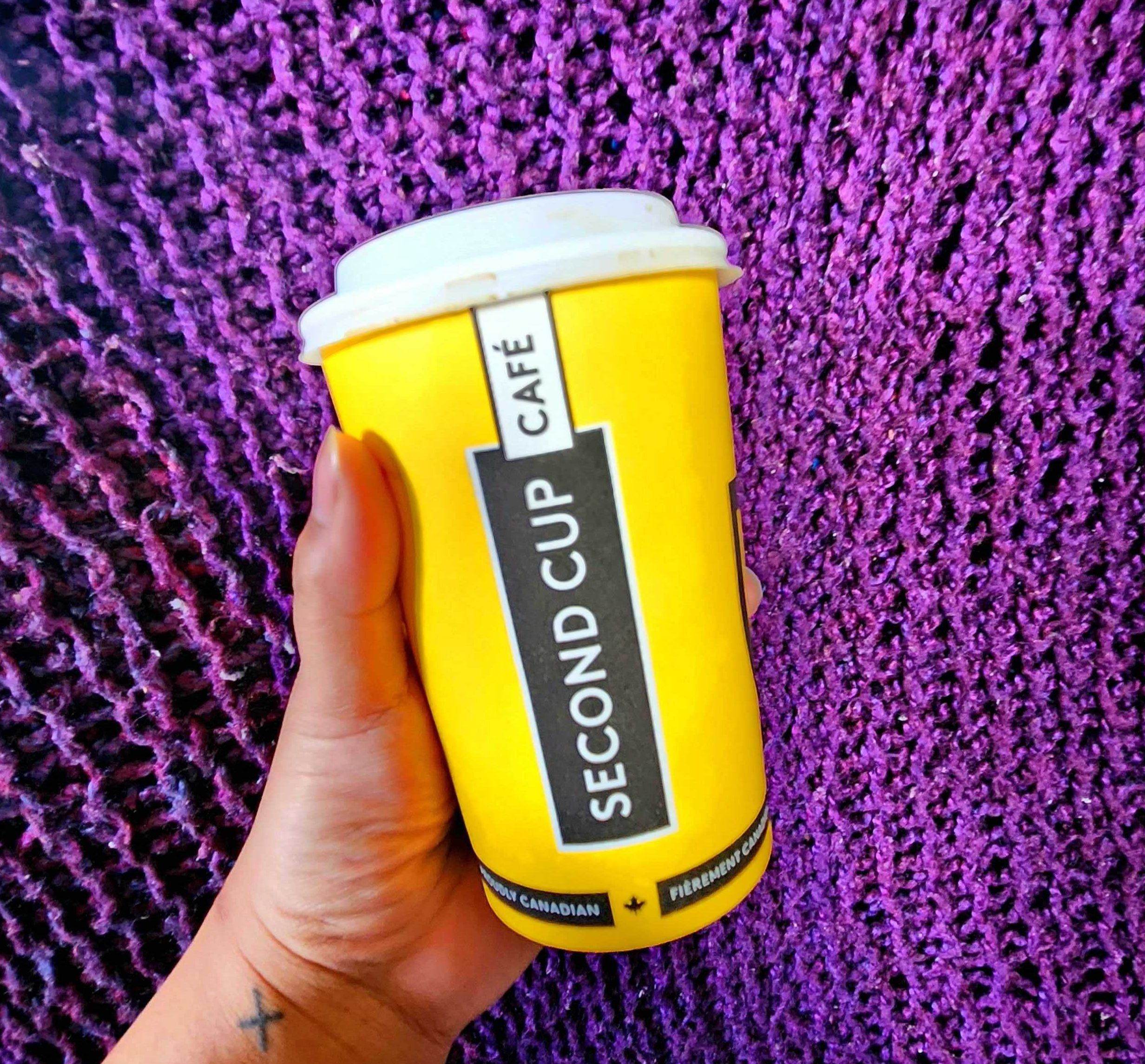 Sarah holding a medium Second Cup coffee.