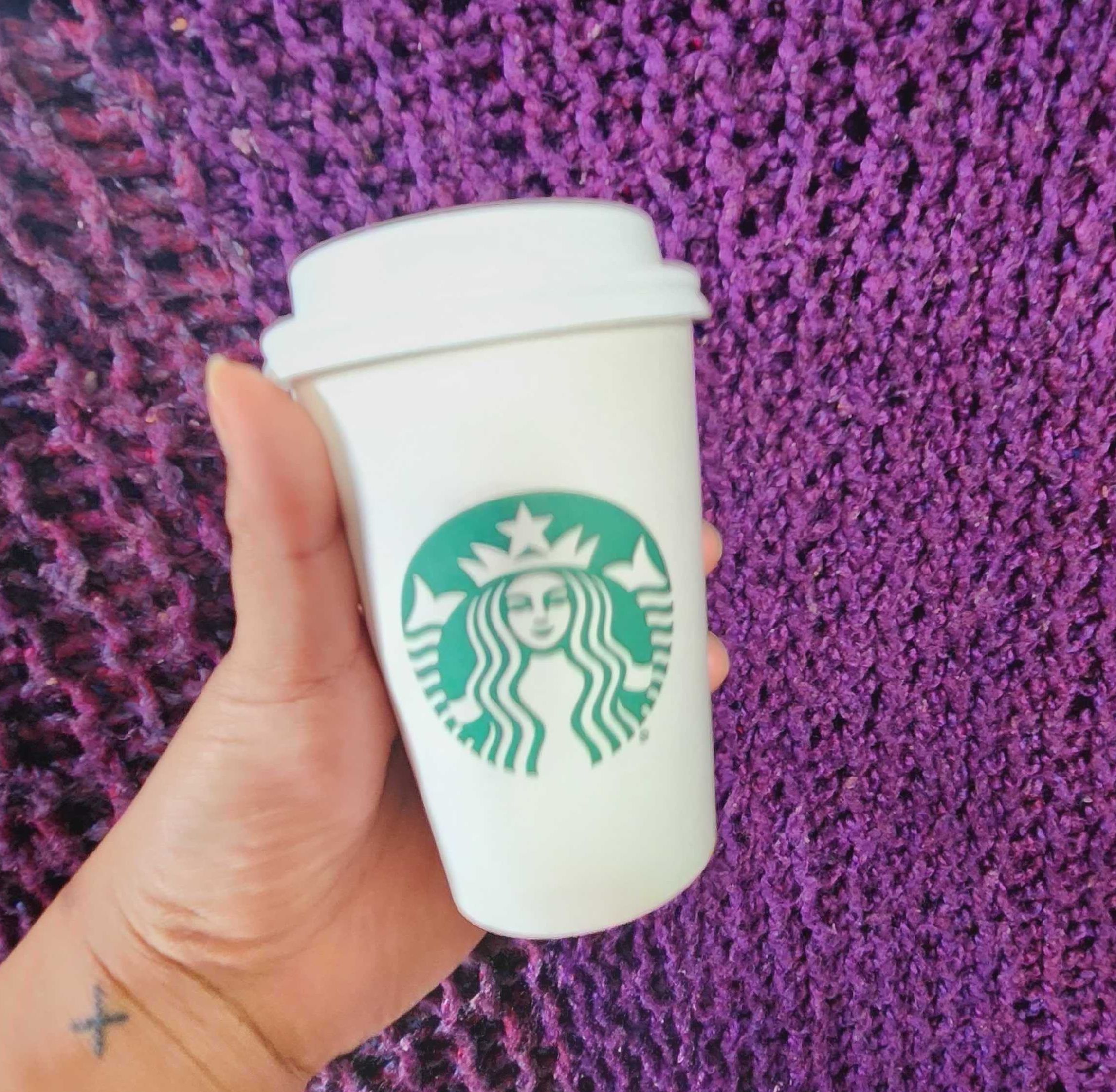 Sarah holding a tall Starbucks coffee.