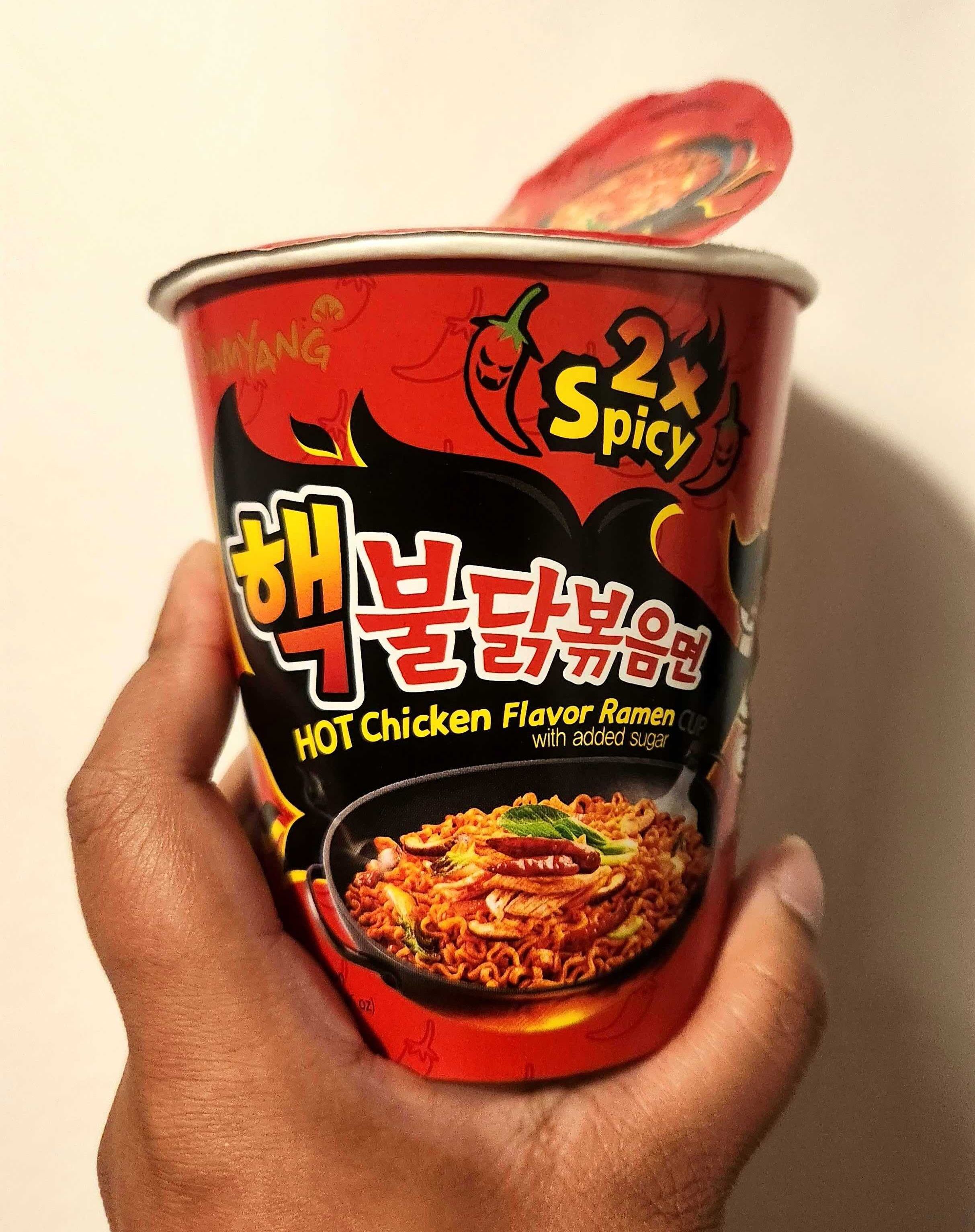 Sarah holding Buldak Hot Chicken Flavour Ramen, 2x spicy.
