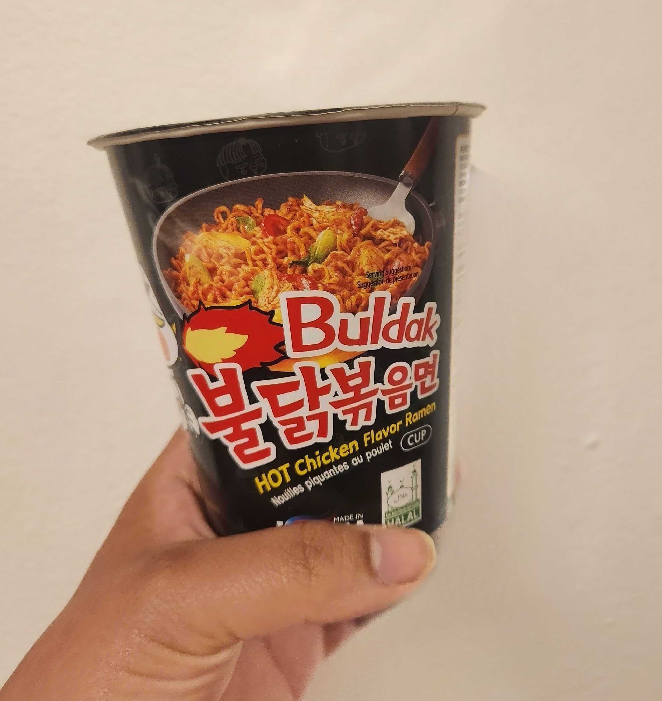 Sarah holding Buldak Hot Chicken Flavour Ramen.