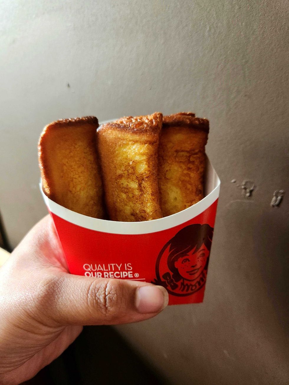 Sarah holding the Homestyle French Toast Sticks that are now available all day.