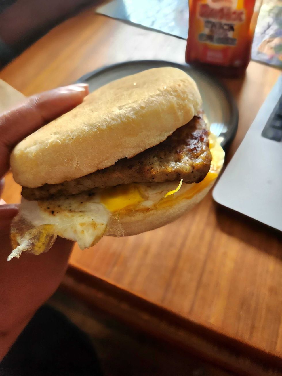 Sarah holding the new Wendy's English Muffin Sandwich with sausage.