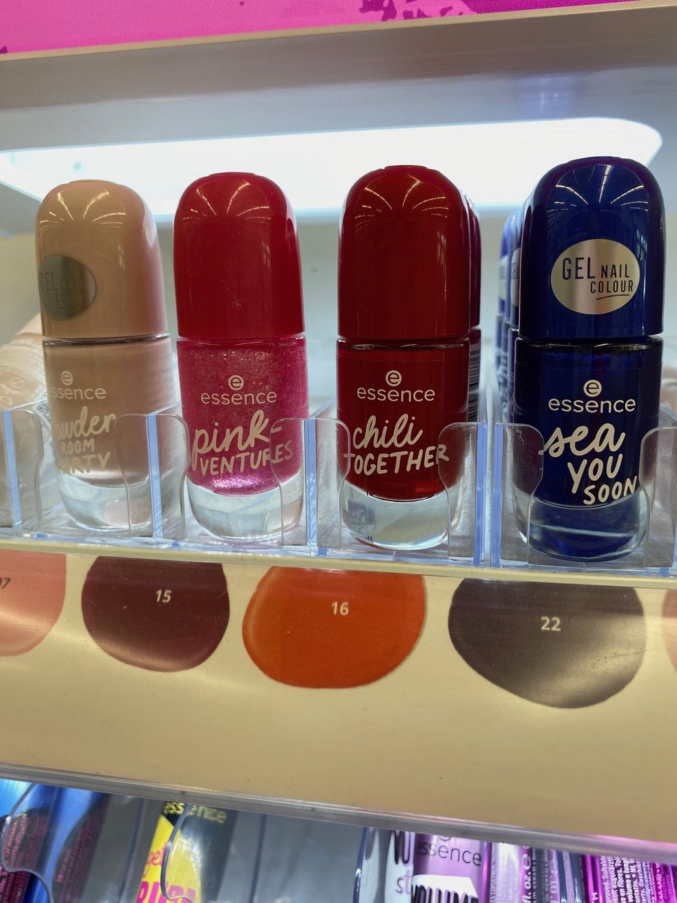 Several bottles of Essence nail polish in various colours on a shelf at Shoppers Drug Mart.