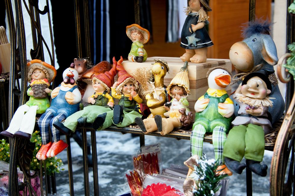 Several puppets sitting on a bench.