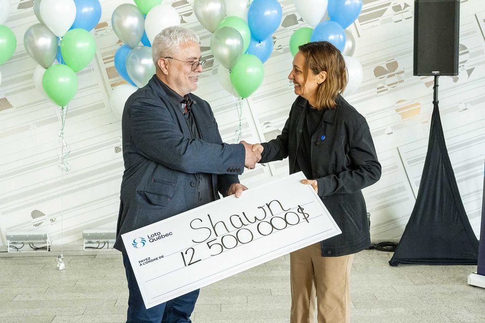 shawn batten holding cheque and shaking hands with loto quebec representative