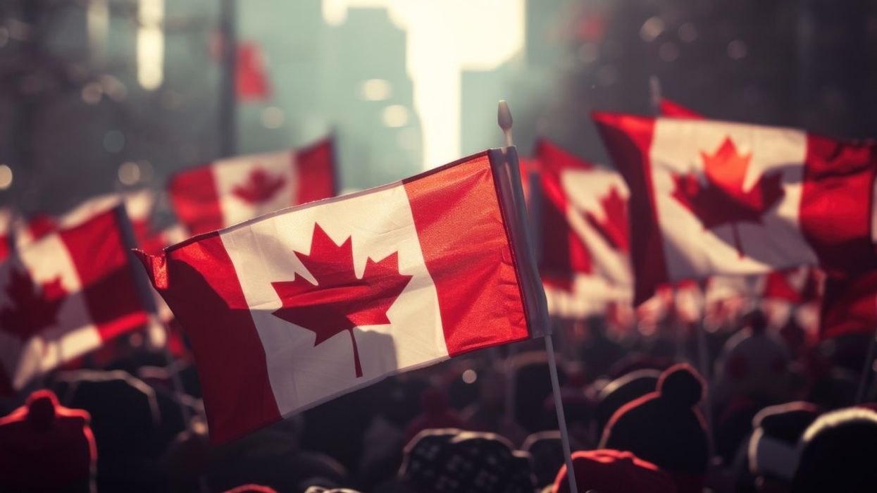 Silhouettes of people holding the Canadian flag on the streets of Toronto.