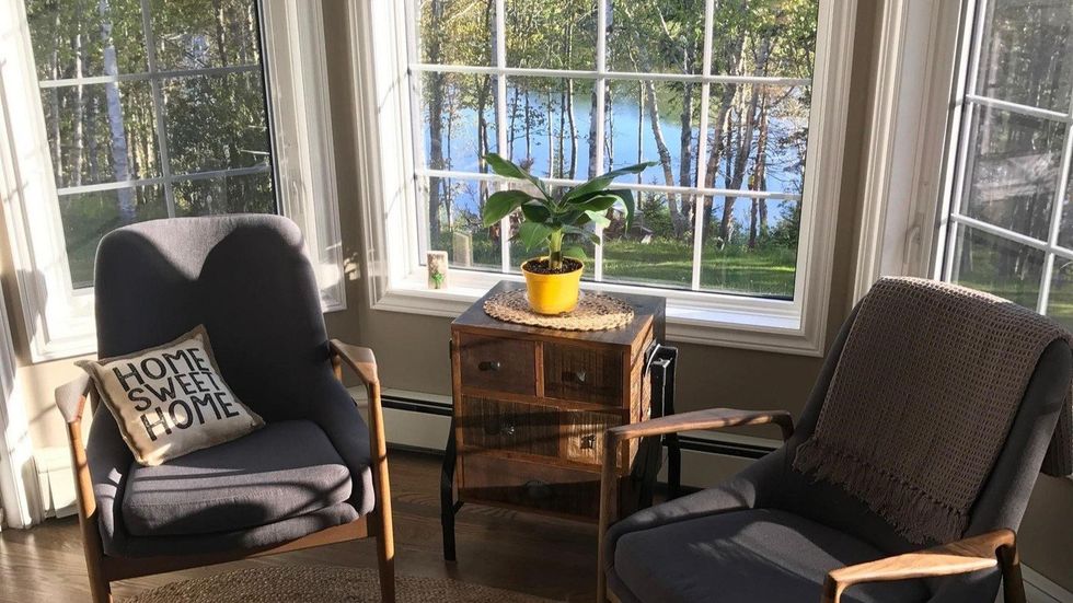 Sitting area in the house with bay windows that have ocean views.