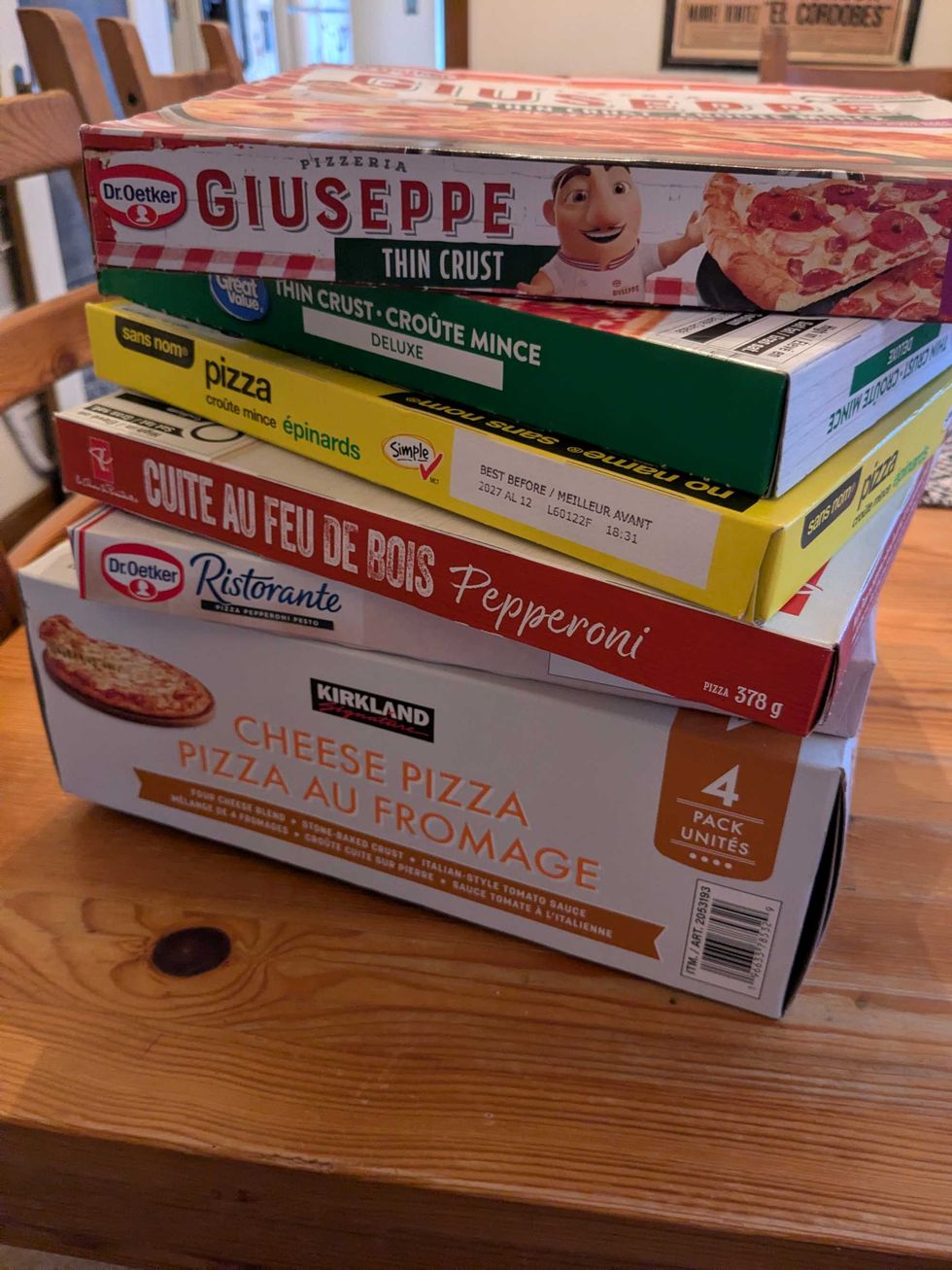 Six boxes of frozen pizza stacked on each other