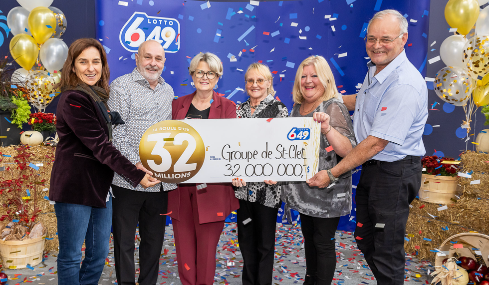 Six personnes tiennent un gros ch\u00e8que de 32 M$ entre leurs mains.