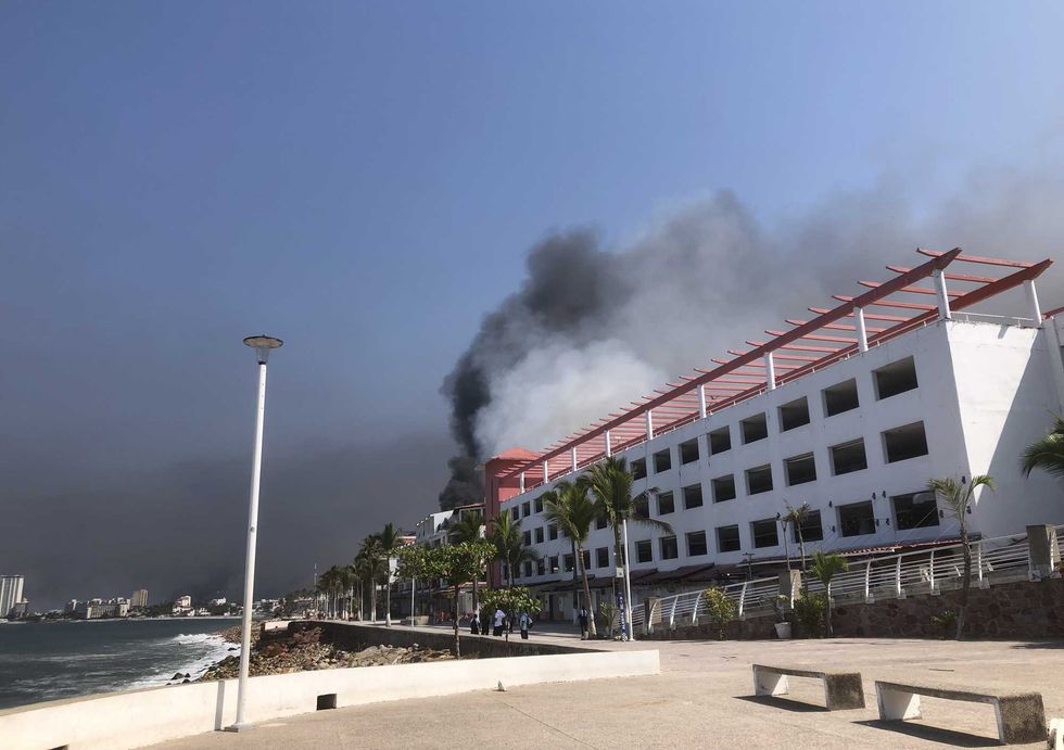 Smoke from car and bus fires beside the boardwalk in the tourist area of Puerto Vallarta, Mexico.