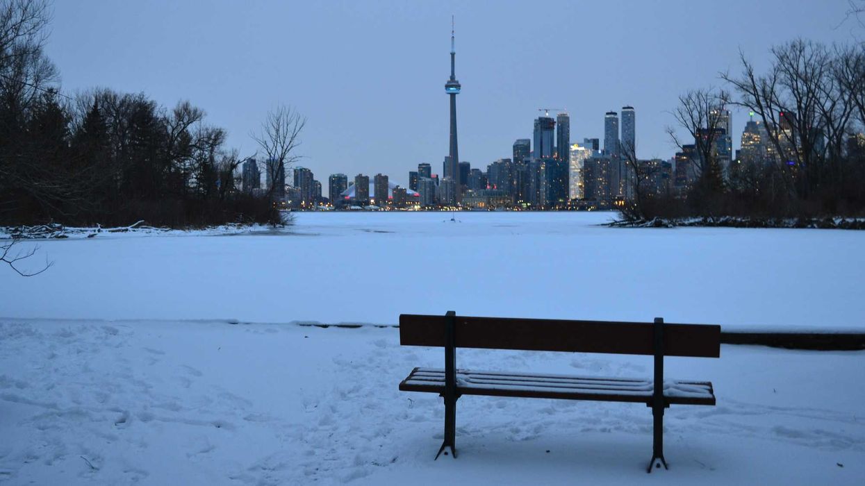 snow covered toronto islands and lake ontario with toronto skyline in background