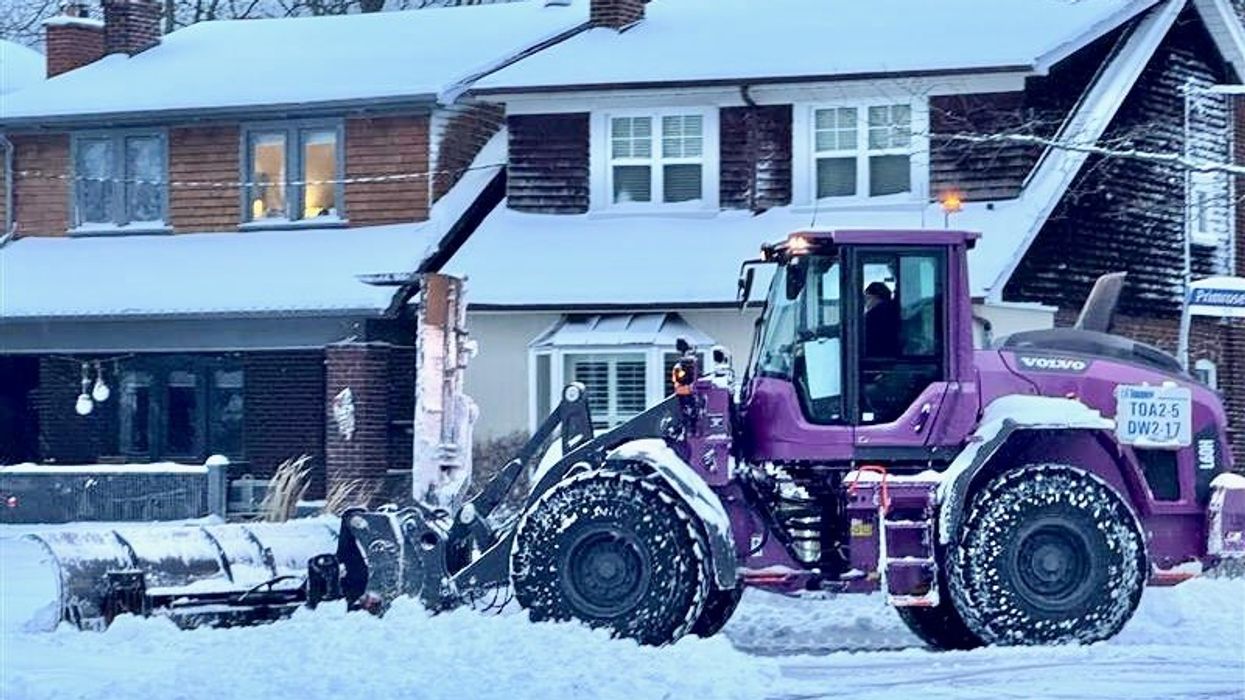 Snowplow clearing a residential Toronto street.