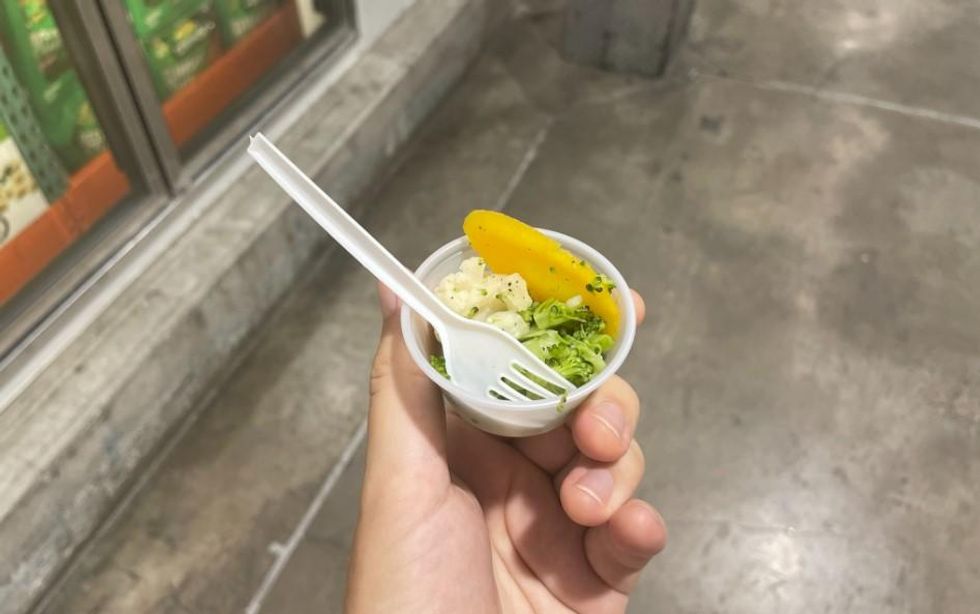 Some veggies in a plastic cup and a fork.