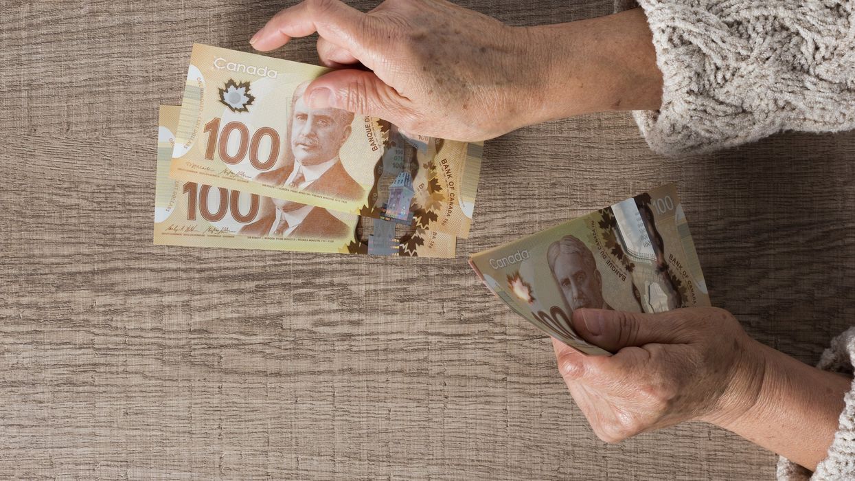 Someone counting Canadian money (illustrative).