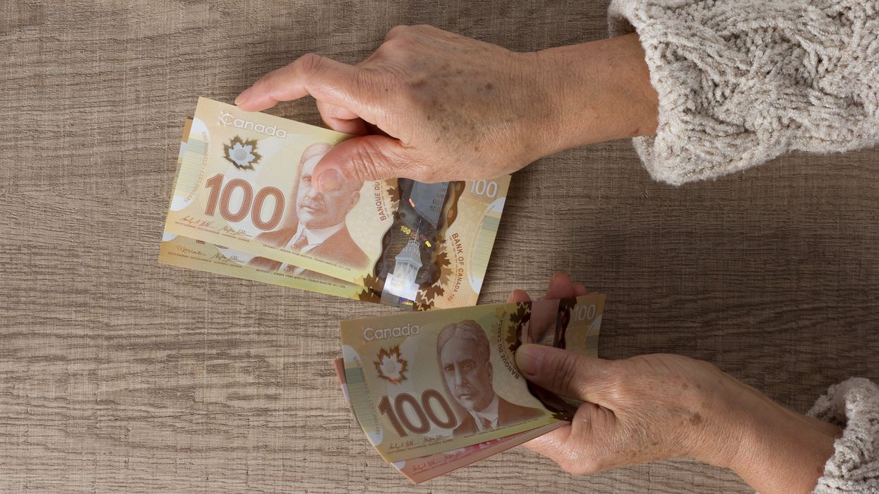 Someone counting Canadian money.