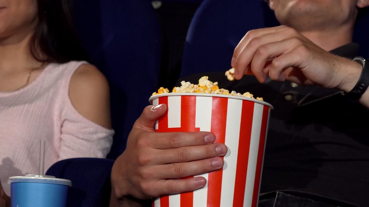 Someone eating popcorn in a theatre.