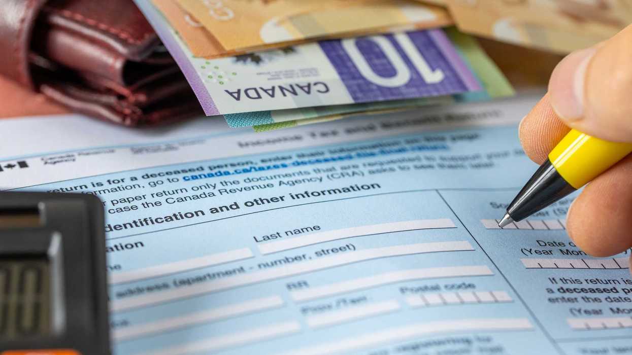 Someone fills out a Canadian income tax return form.