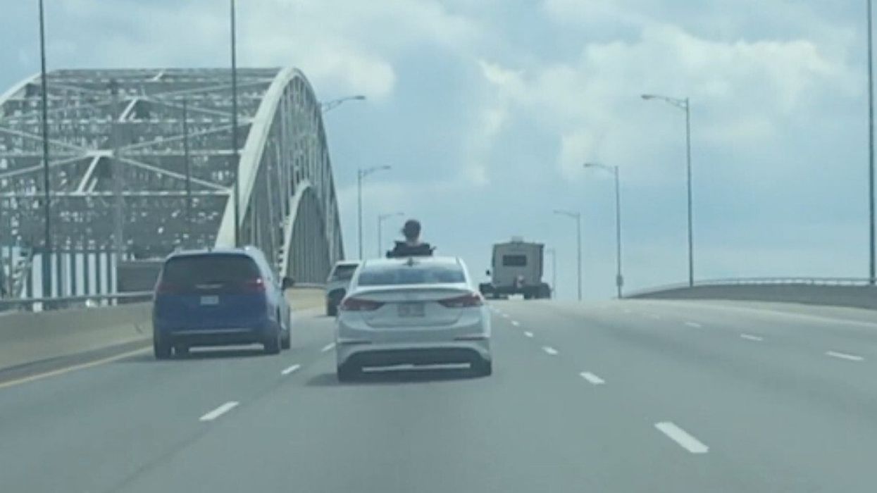 Someone hanging outside sunroof on the QEW.
