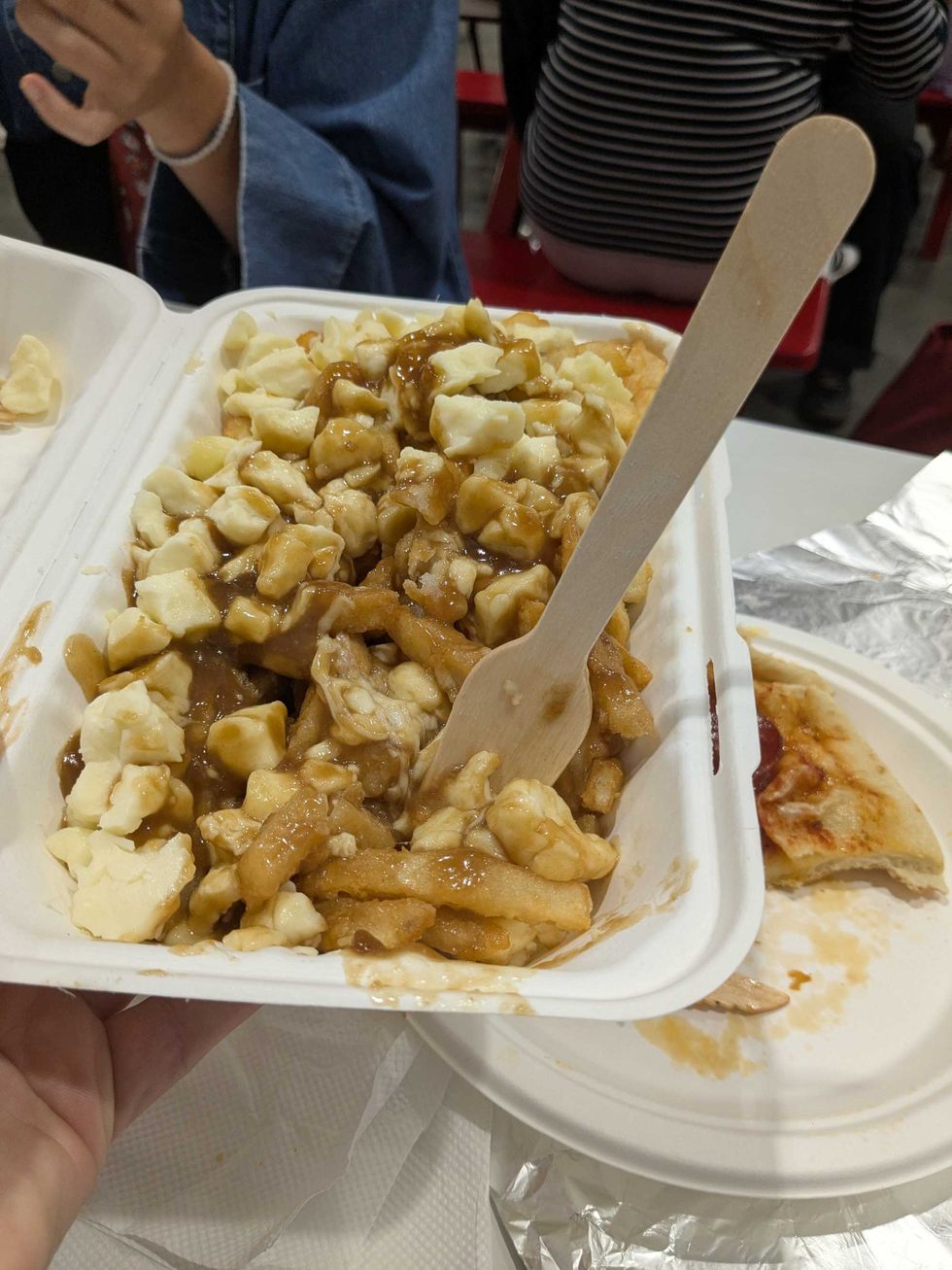 Someone holding a box of poutine