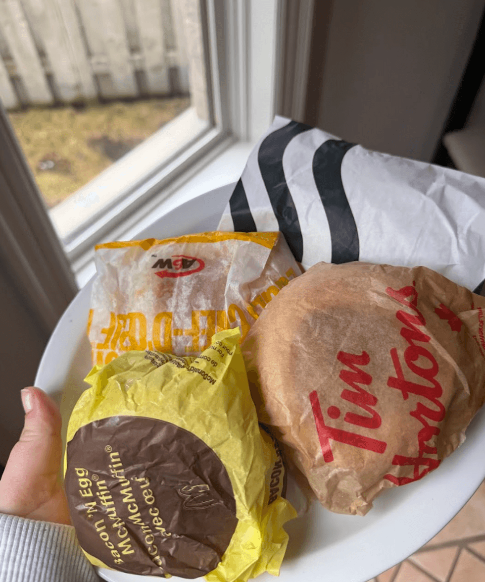 Someone holding a breakfast sandwich.