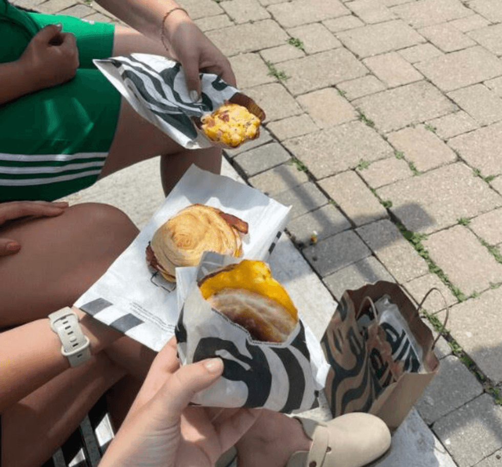 Someone holding a breakfast sandwich.