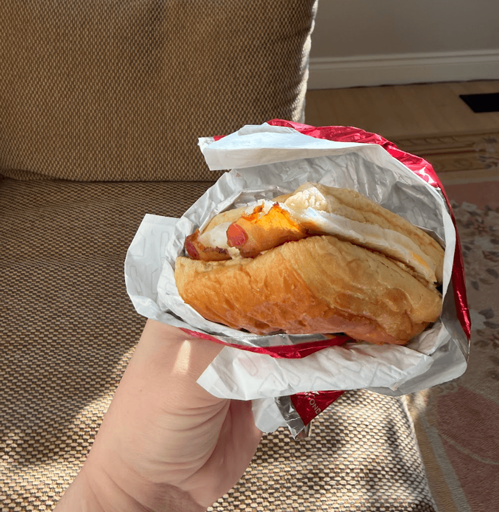 Someone holding a breakfast sandwich.