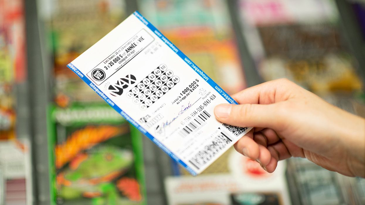 Someone holding a Lotto Max ticket (illustrative).