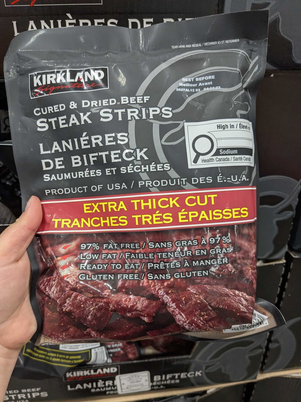 Someone holding a package of Kirkland beef jerky