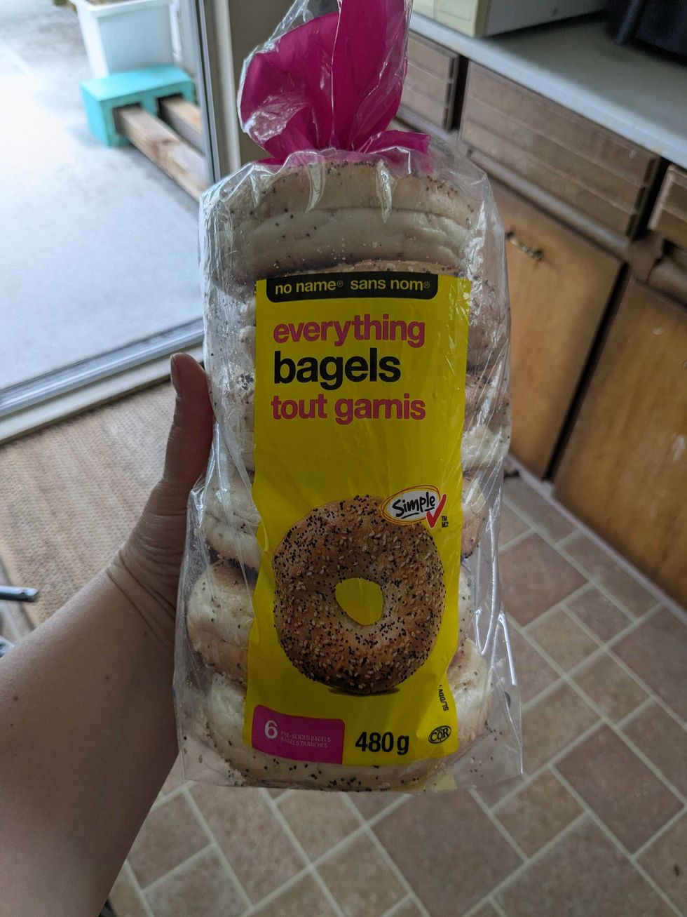 Someone holding a package of No Name bagels