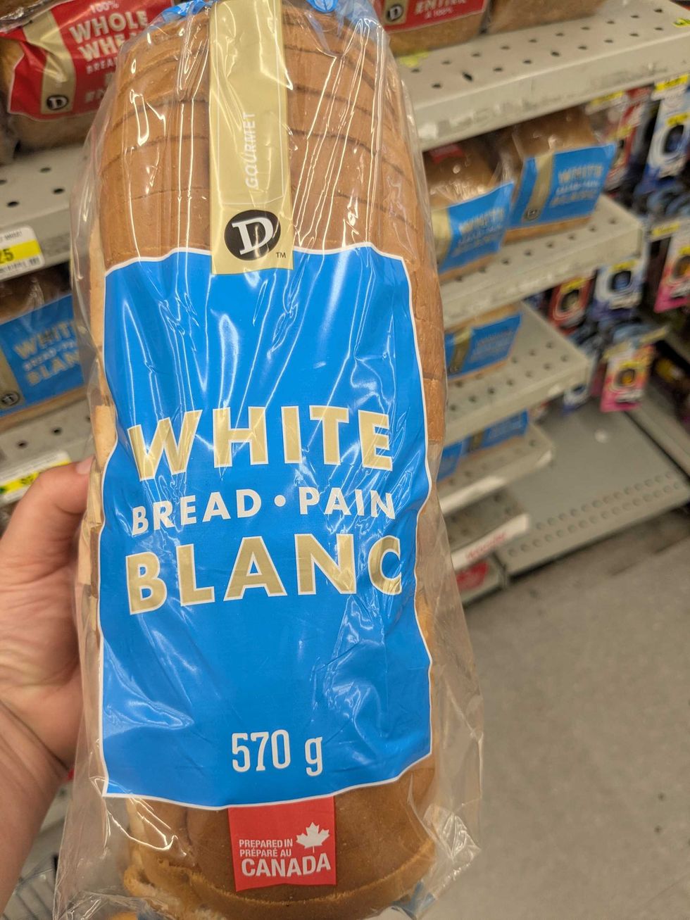Someone holding a package of white bread at Dollarama
