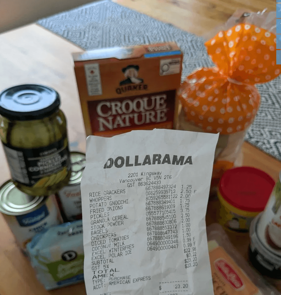 Someone holding a receipt in front of a bunch of good products on a table.