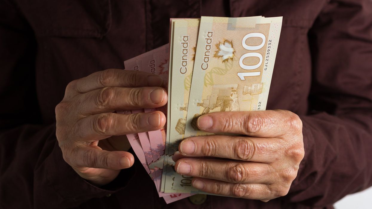 Someone holding Canadian banknotes (illustrative).