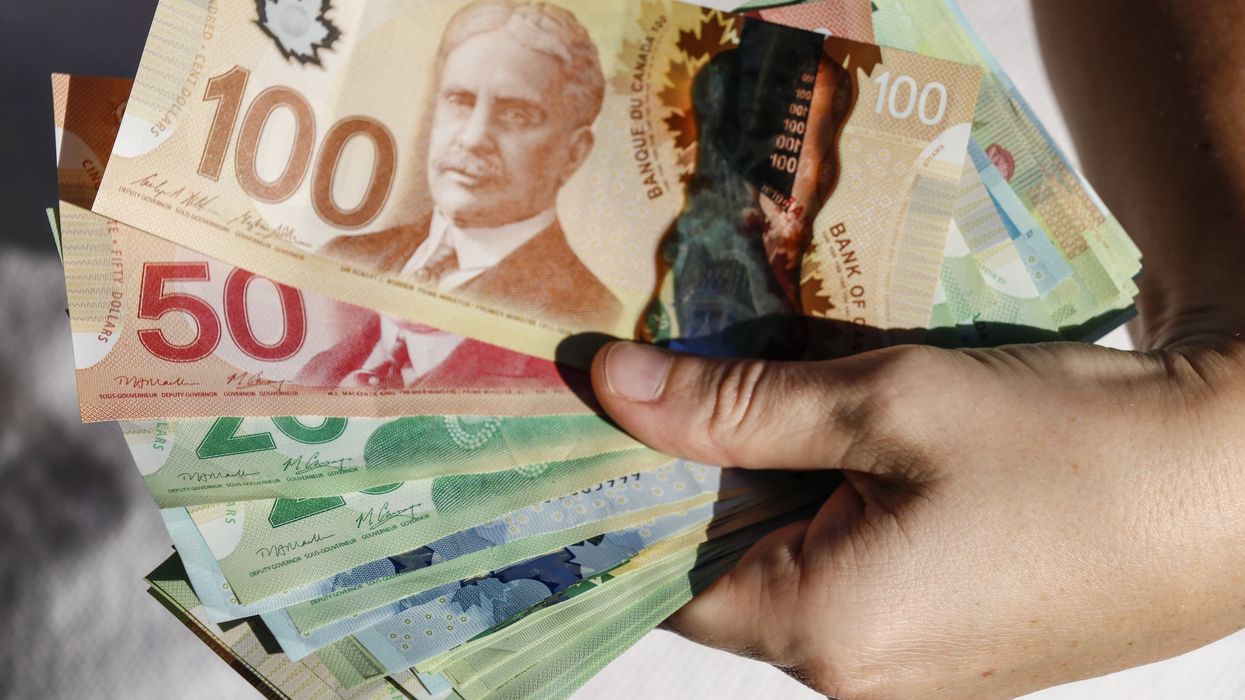 Someone holding Canadian money.