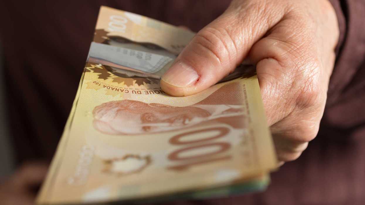 Someone holding Canadian money.