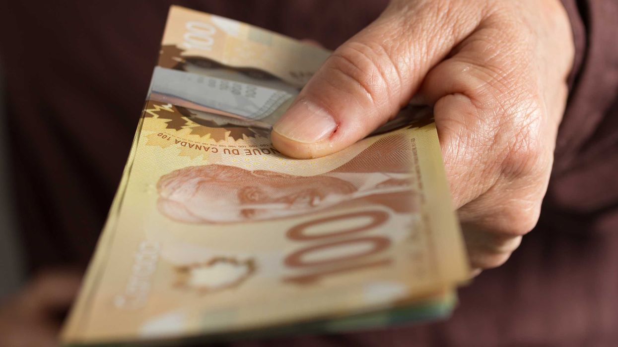 Someone holding Canadian money.