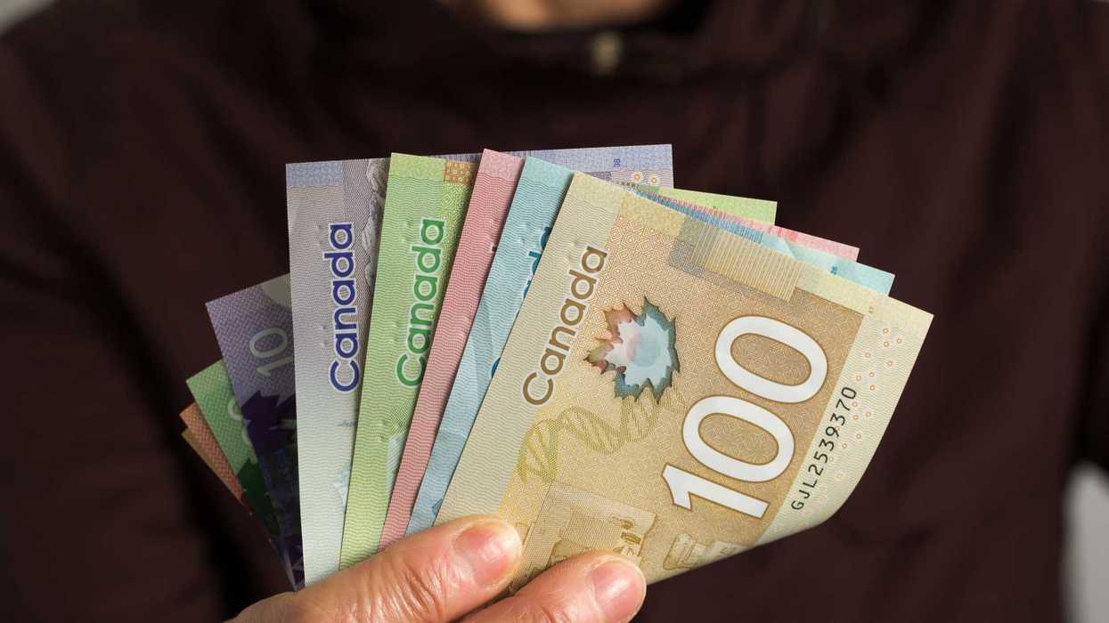 Someone holding Canadian money.