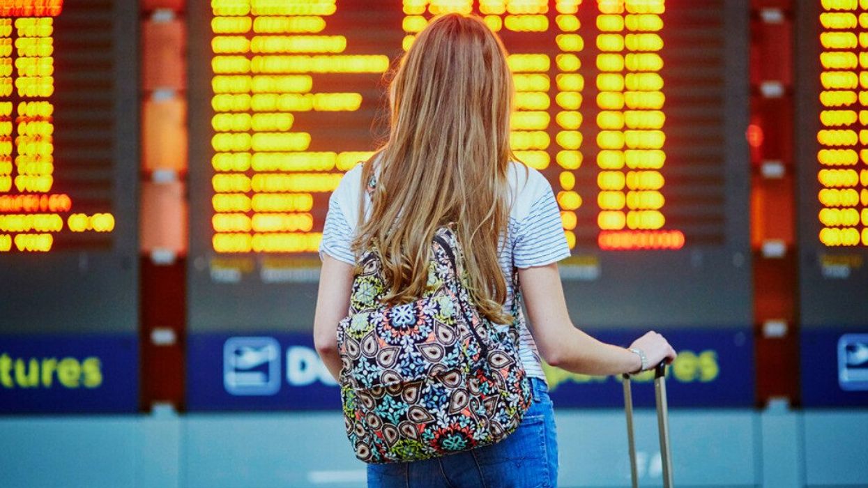 Someone looking at an airport departures board.